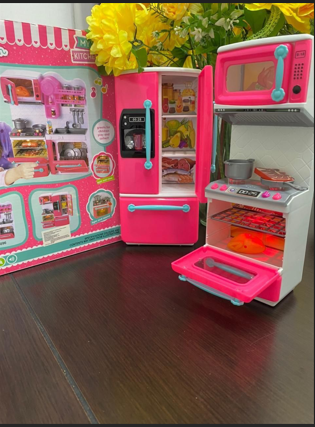 Cocina de juguete con puertas de nevera y horno abiertas
