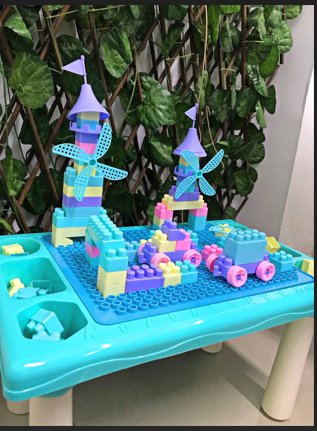 Mesa infantil con bloques de construcción y compartimentos laterales