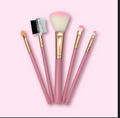 Set de cinco herramientas de maquillaje con mangos rosados y detalles dorados